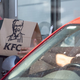 KFC worker hands bag of food to drive-thru customer